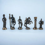 Six small metallic figurines resembling ancient or classical game pieces arranged in a row on a light blue background.