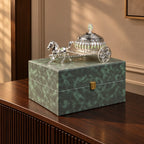 Luxury silver horse-drawn carriage showpiece featuring an intricately crafted ornamental carriage with an elegant domed lidded design, detailed filigree patterns, decorative crystal-like embellishments, finely sculpted horse figurine and beautifully designed spoked wheels. The polished silver finish and elaborate craftsmanship make it an elegant statement piece for luxury home décor, display cabinets and sophisticated interiors.