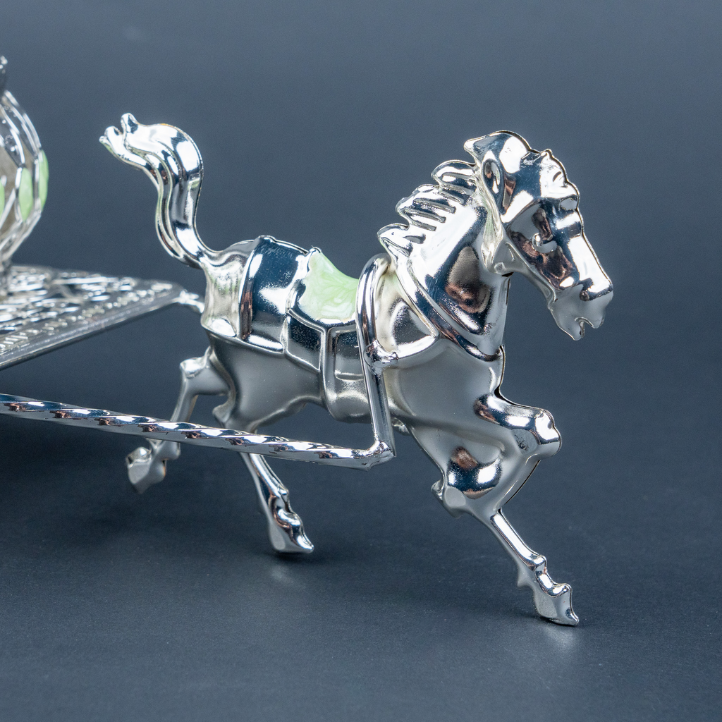 Luxury silver horse-drawn carriage showpiece featuring an intricately crafted ornamental carriage with an elegant domed lidded design, detailed filigree patterns, decorative crystal-like embellishments, finely sculpted horse figurine and beautifully designed spoked wheels. The polished silver finish and elaborate craftsmanship make it an elegant statement piece for luxury home décor, display cabinets and sophisticated interiors.