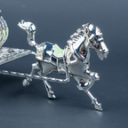 Luxury silver horse-drawn carriage showpiece featuring an intricately crafted ornamental carriage with an elegant domed lidded design, detailed filigree patterns, decorative crystal-like embellishments, finely sculpted horse figurine and beautifully designed spoked wheels. The polished silver finish and elaborate craftsmanship make it an elegant statement piece for luxury home décor, display cabinets and sophisticated interiors.