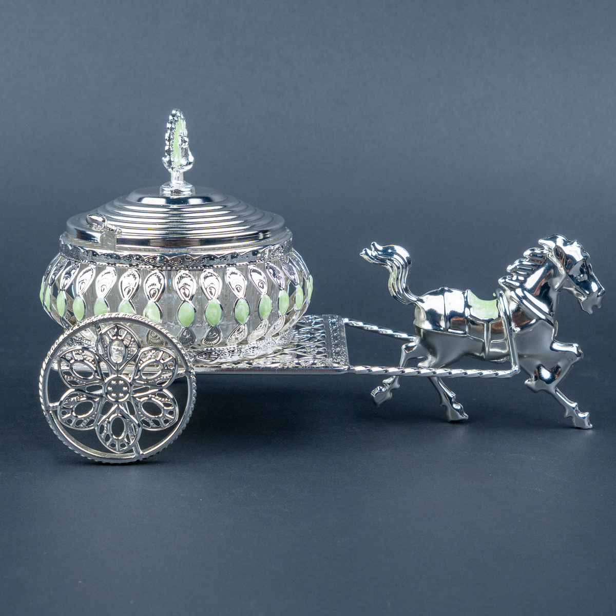 Luxury silver horse-drawn carriage showpiece featuring an intricately crafted ornamental carriage with an elegant domed lidded design, detailed filigree patterns, decorative crystal-like embellishments, finely sculpted horse figurine and beautifully designed spoked wheels. The polished silver finish and elaborate craftsmanship make it an elegant statement piece for luxury home décor, display cabinets and sophisticated interiors.