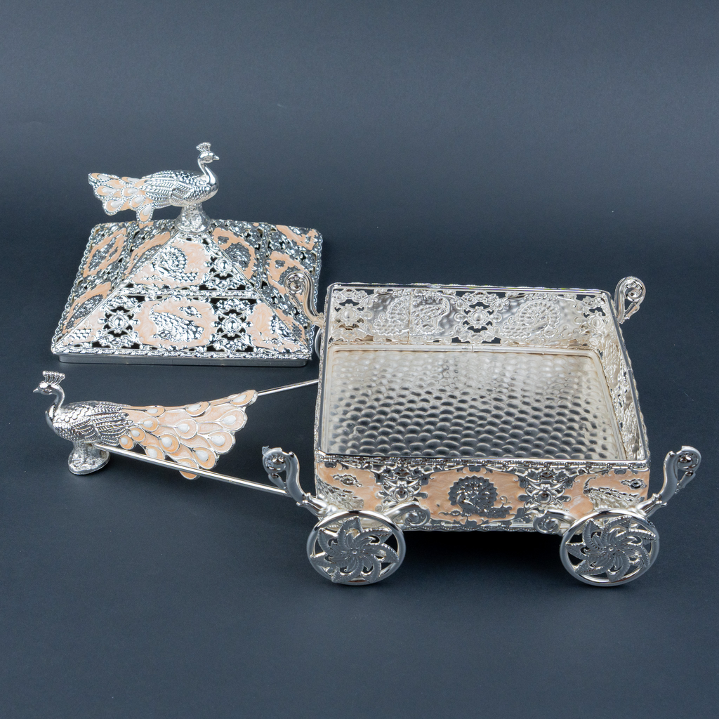 Intricately crafted silver decorative horse-drawn chariot showpiece featuring an ornate miniature carriage with an elegant pyramid-shaped roof, detailed floral and filigree engravings, decorative silver horse figurines, and beautifully sculpted ornamental wheels. Its polished metallic finish and intricate craftsmanship make it a luxurious statement piece for living room décor, display cabinets and premium interiors.
