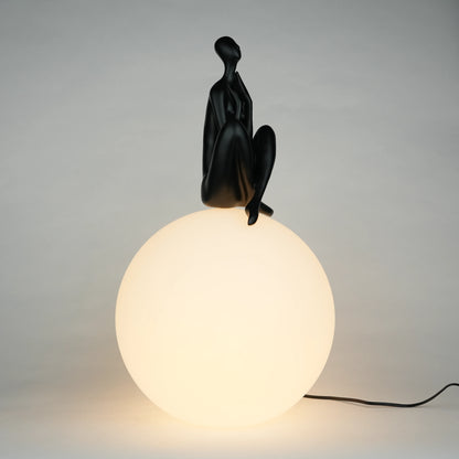 Black human sculpture seated on glowing sphere – Glow Contemplation Lamp