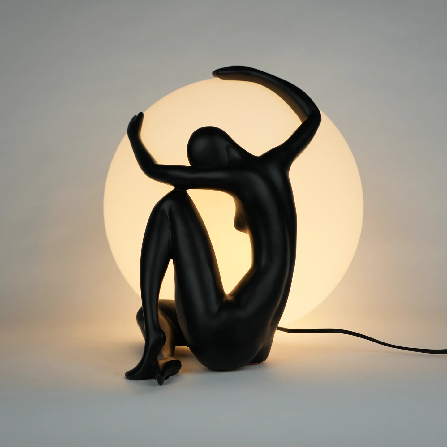 Black human sculpture lamp embracing glowing orb – Midnight Embrace Lamp