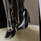 Chrome angel figurine with gold wings seated in a modern pose.