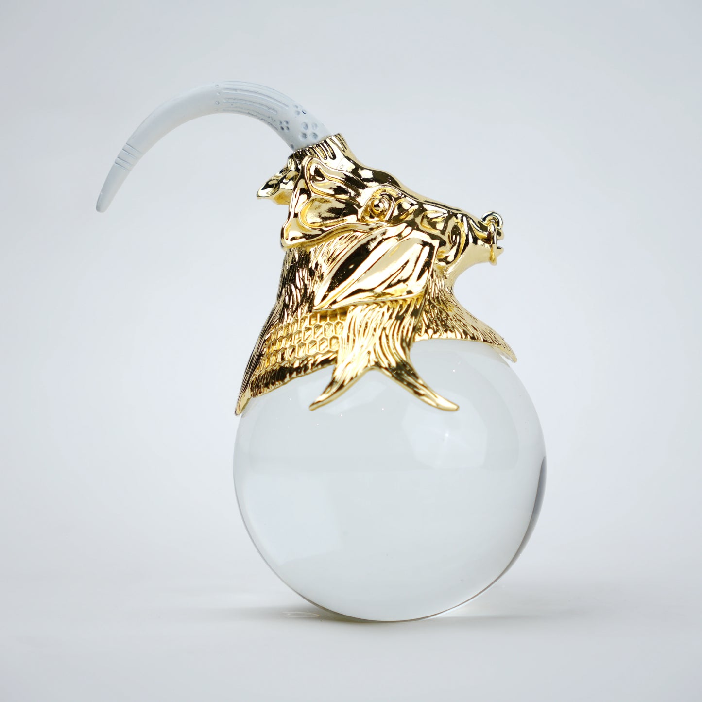 Decorative object with gold lion head and white sphere