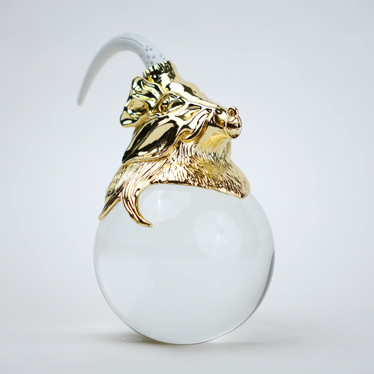 Decorative object with gold lion head and white sphere