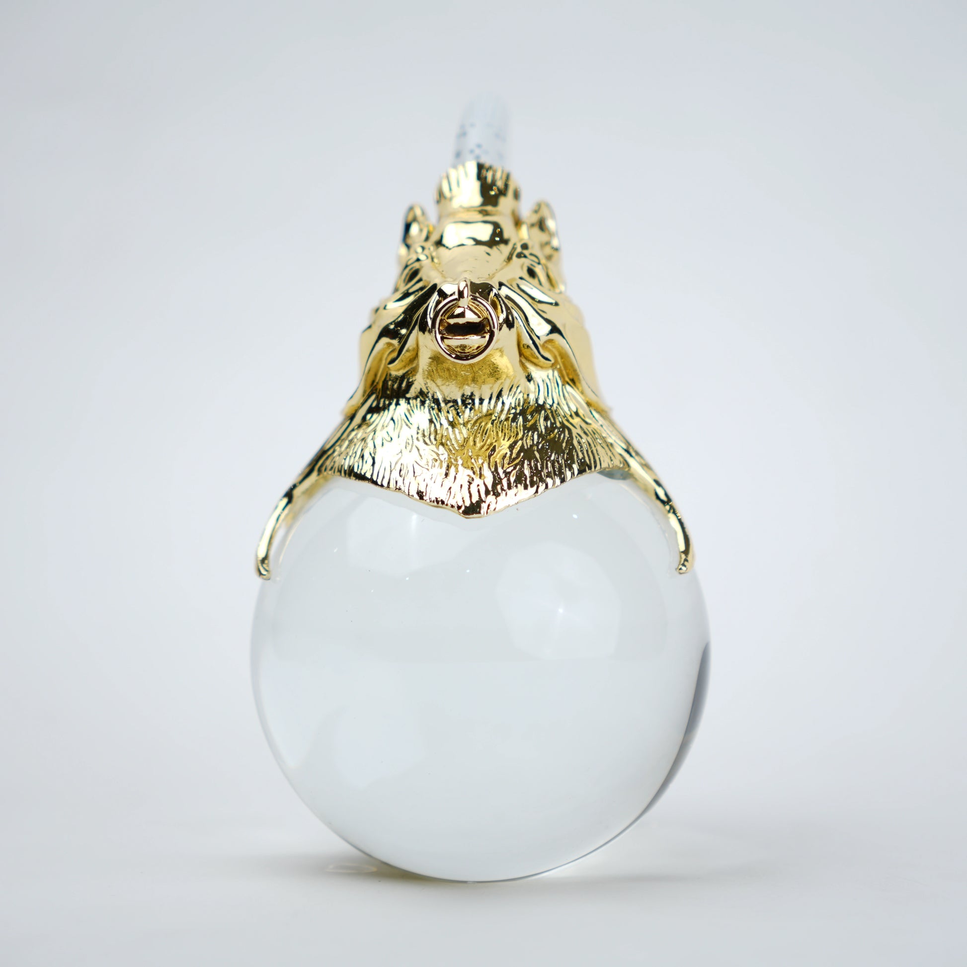 Decorative object with gold lion head and white sphere