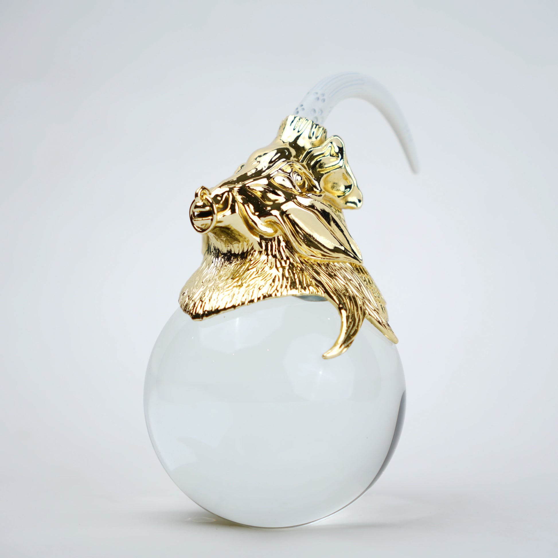 Decorative object with gold lion head and white sphere