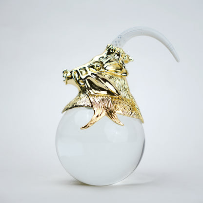 Decorative object with gold lion head and white sphere