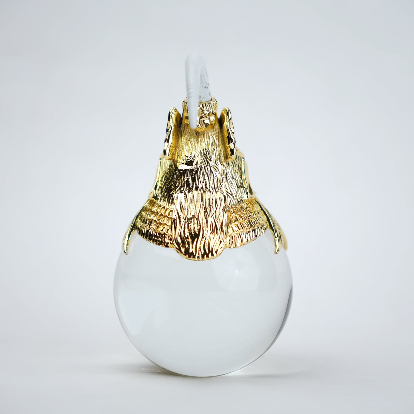 Decorative object with gold lion head and white sphere
