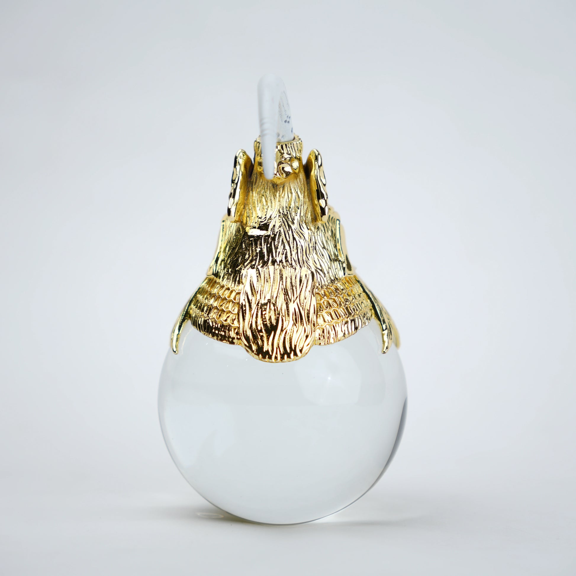 Decorative object with gold lion head and white sphere