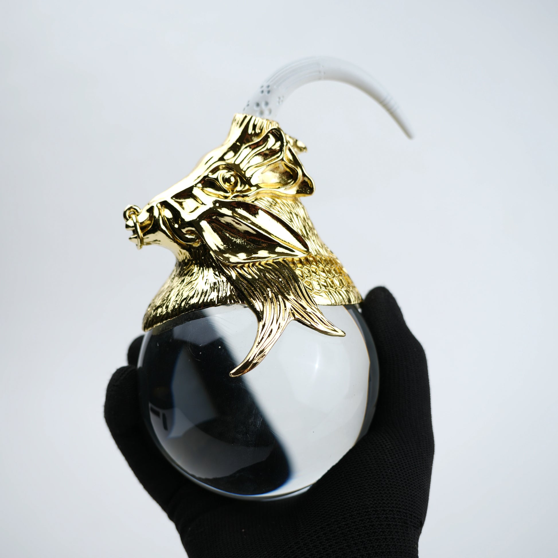 Decorative object with gold lion head and white sphere