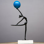 Abstract ballerina figurine sculpture balancing a blue sphere with graceful contemporary form