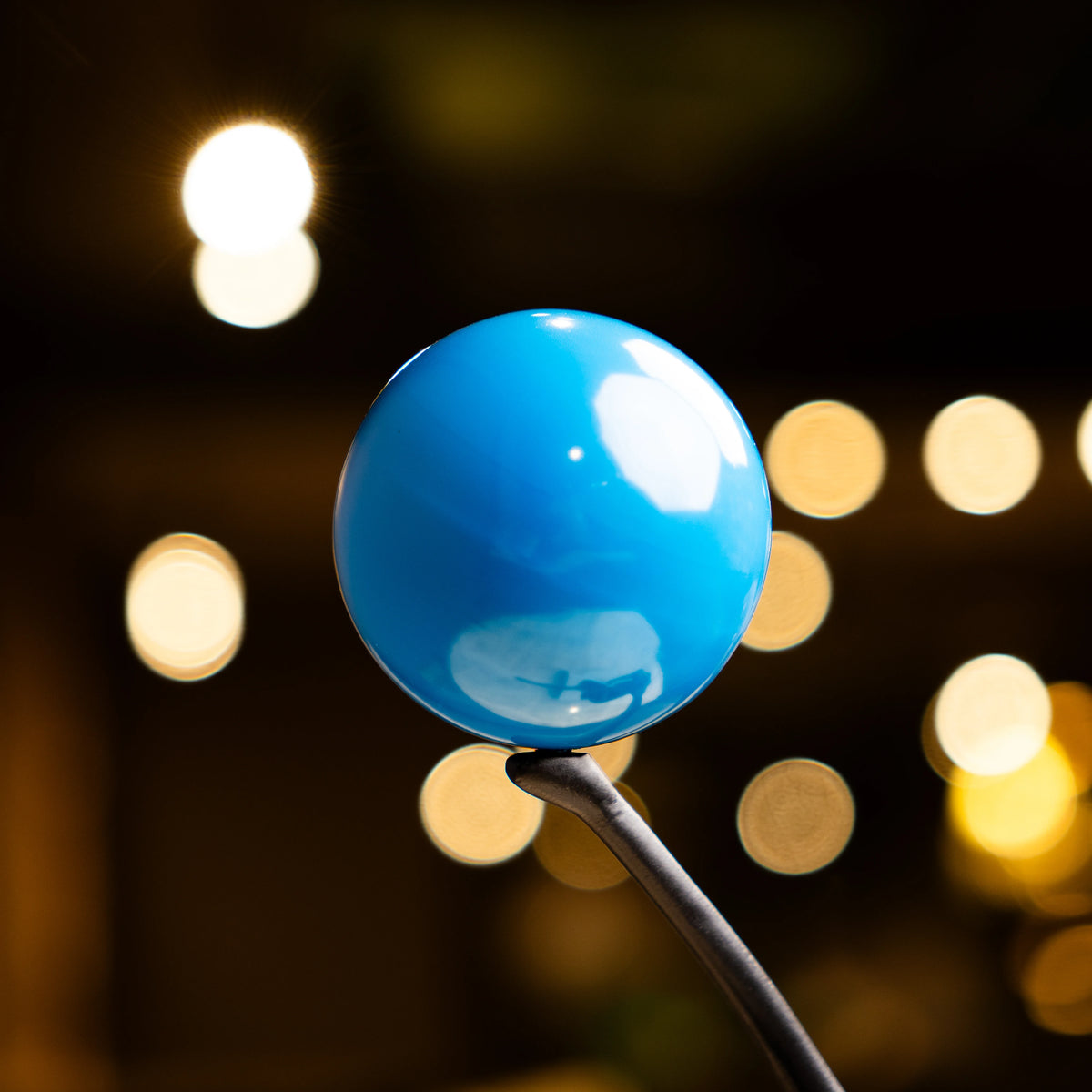 Abstract ballerina figurine sculpture balancing a blue sphere with graceful contemporary form