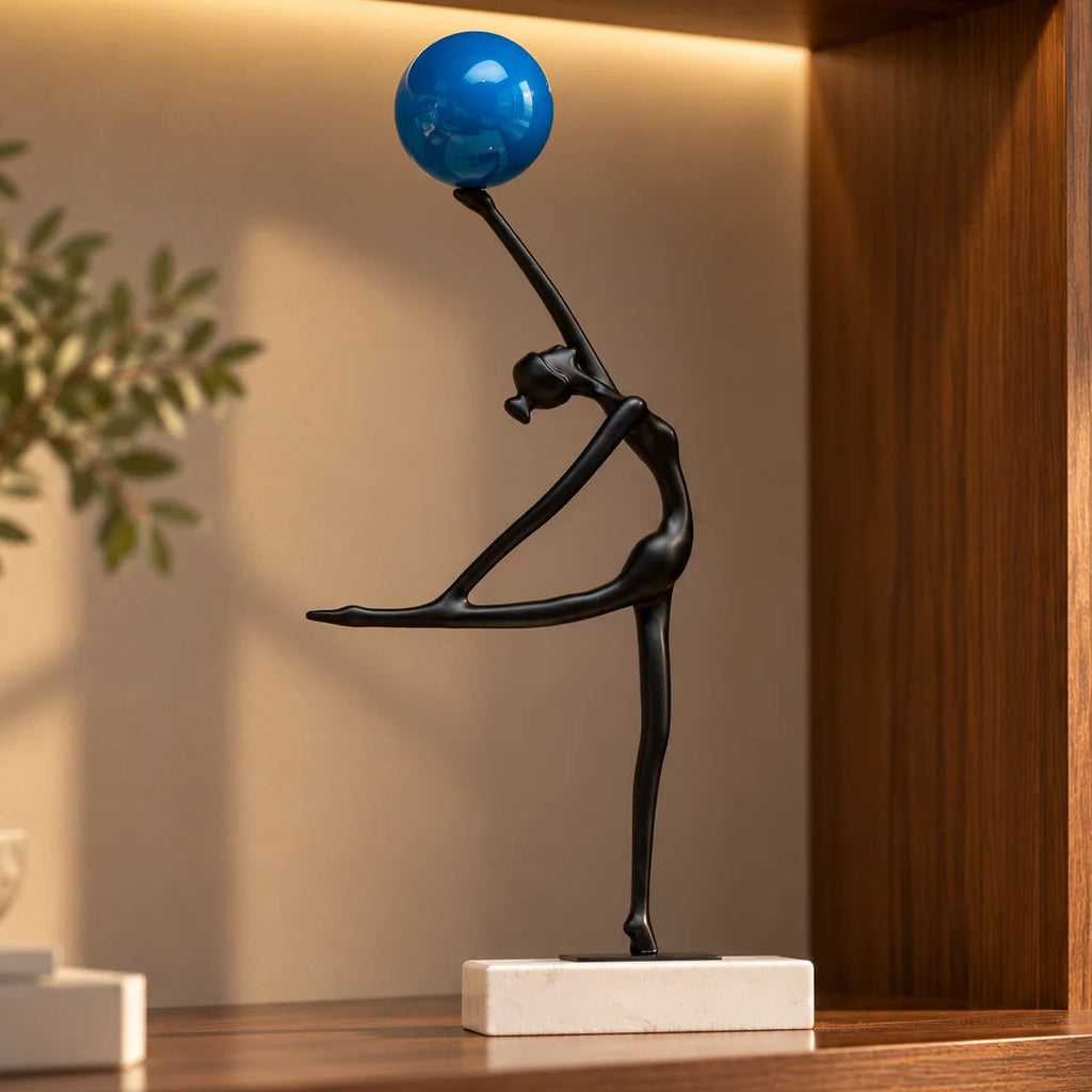 Abstract ballerina figurine sculpture balancing a blue sphere with graceful contemporary form