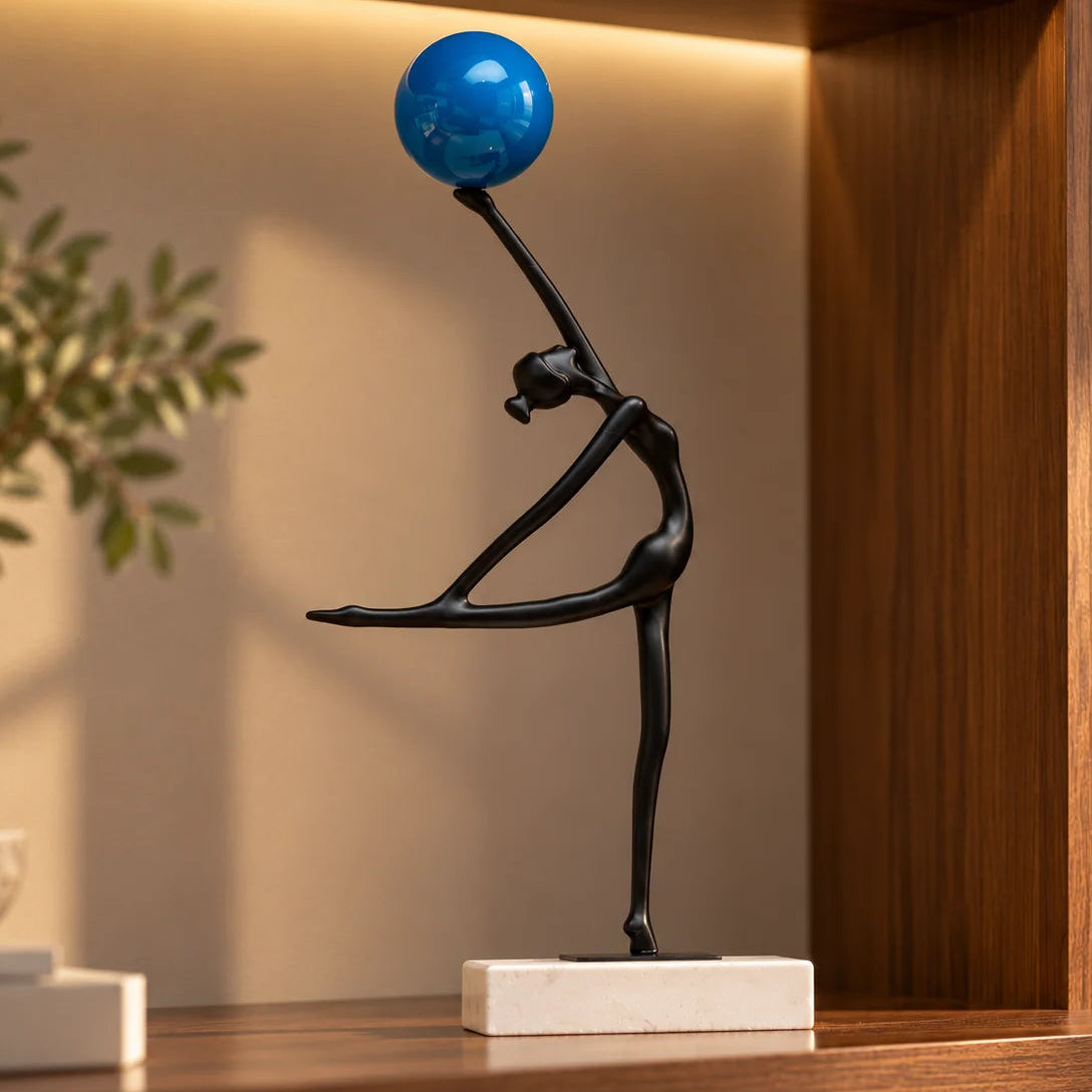 Abstract ballerina figurine sculpture balancing a blue sphere with graceful contemporary form