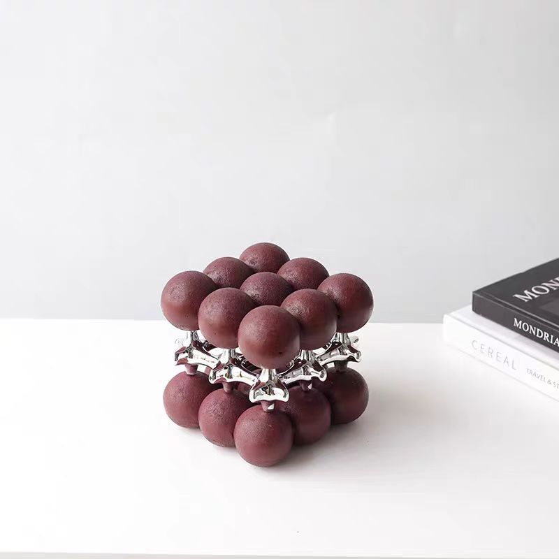 Maroon sphere cube beside Mondrian books