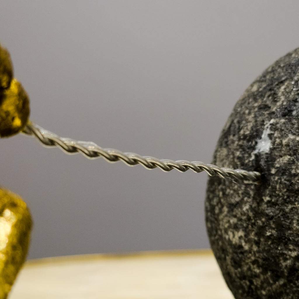 Golden resin figure pulling boulder, macro