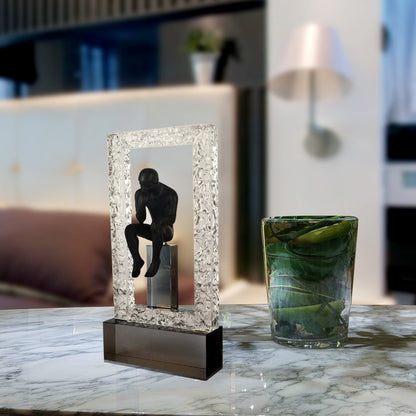 A premium black resin and metal sculpture of a contemplative thinker seated in reflection with a sturdy base, ideal for home and office decor.