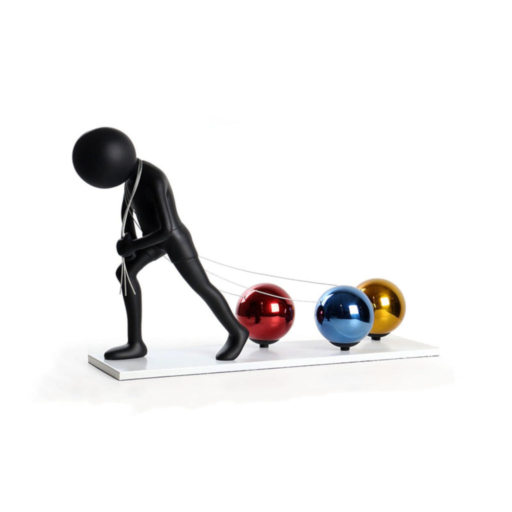 Hardworking Man pulling metallic spheres, side