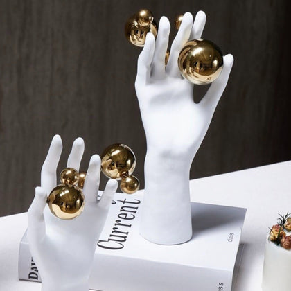 Abstract right hand on books, gold spheres