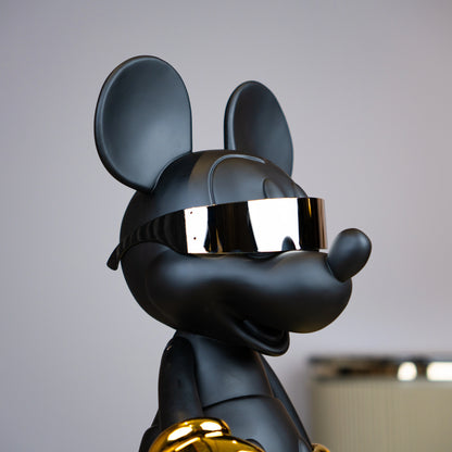 Black matte mascot figurine with gold gloves and chrome visor — Cyberpunk Mascot by Ghar Art, futuristic luxury tabletop decor sculpture.