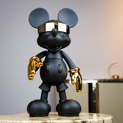 Black matte mascot figurine with gold gloves and chrome visor — Cyberpunk Mascot by Ghar Art, futuristic luxury tabletop decor sculpture.