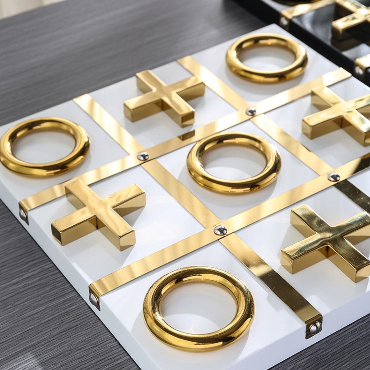 Tic-tac-toe close-up, gold X & O on white grid