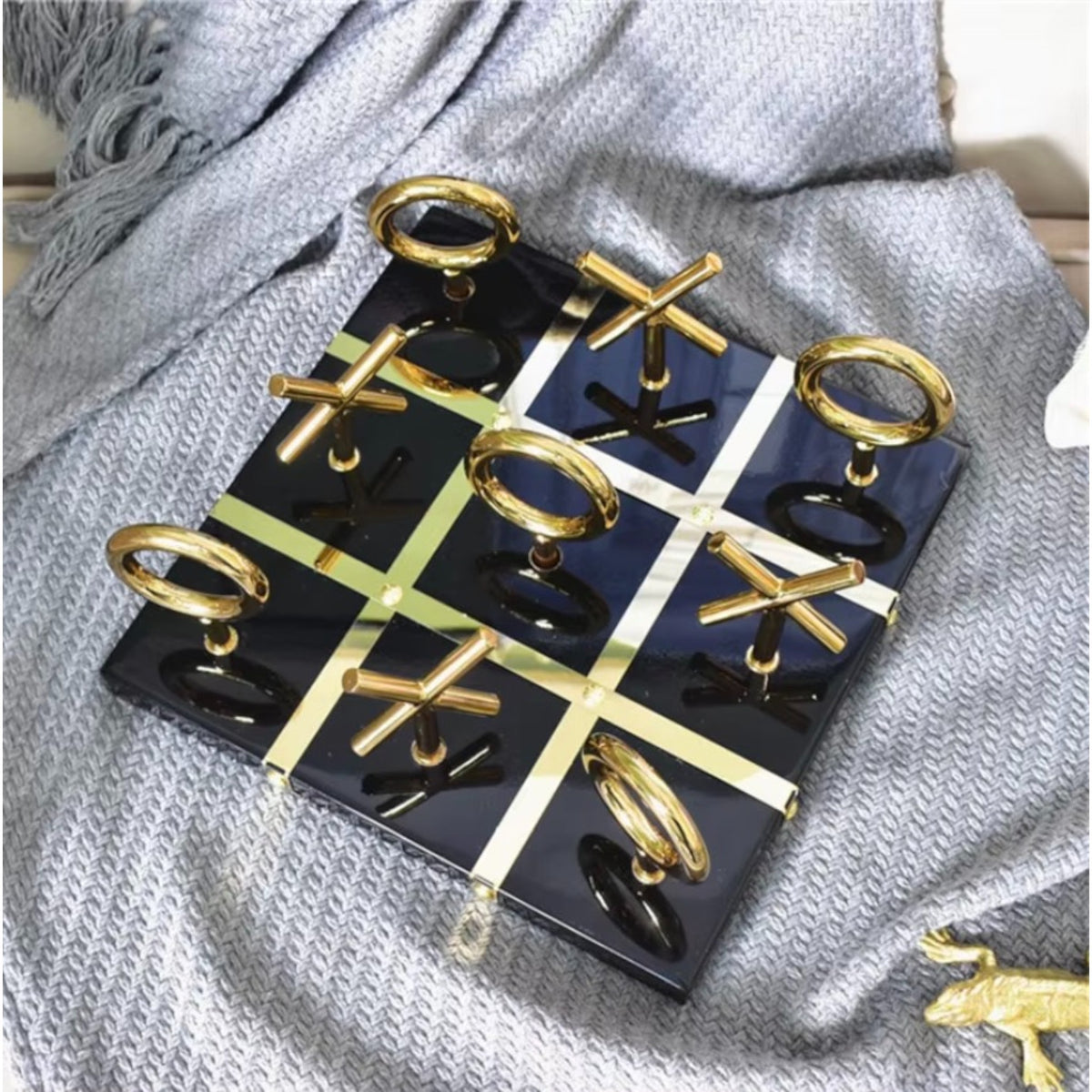 Tic Tac Toe on knit throw, gold pieces styled