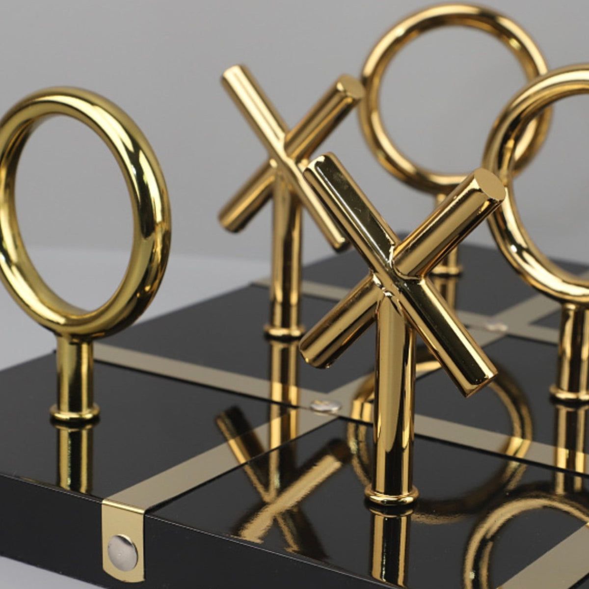 Tic-tac-toe set close-up, black board gold X