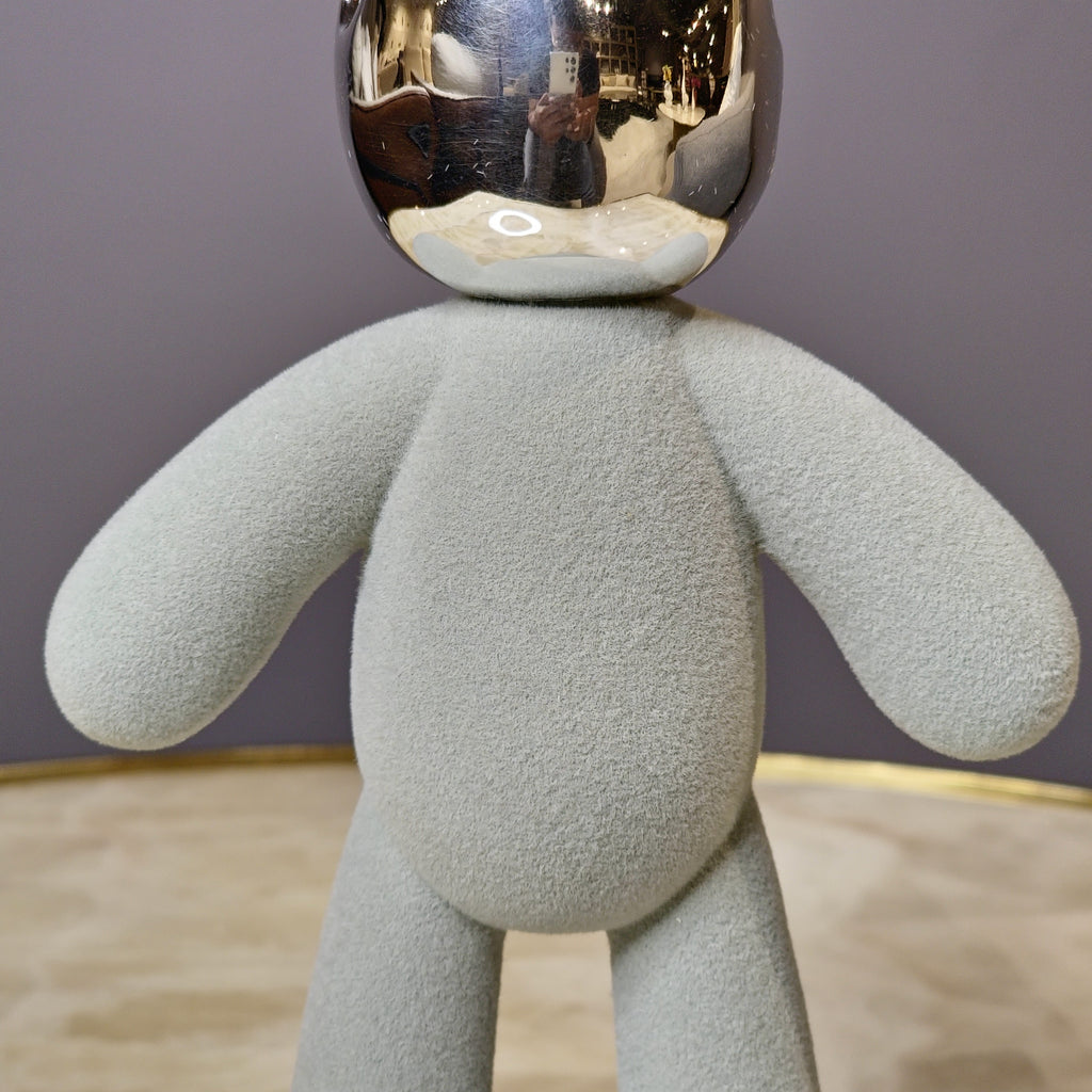 Artistic tabletop figurine designed with a soft texture and metallic accents.