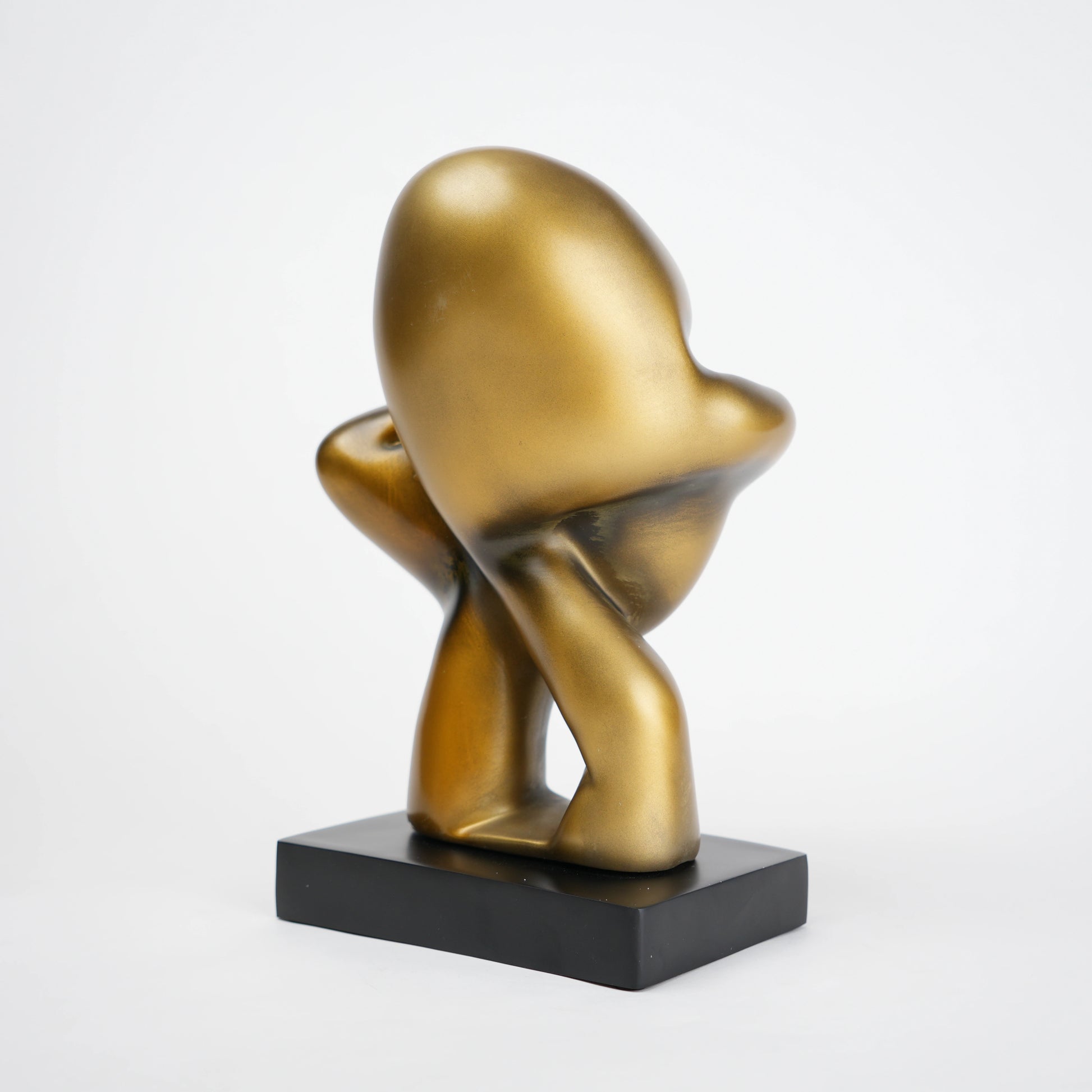 Abstract human decor object in matte gold finish with black base for modern home styling