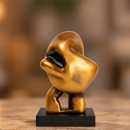 Abstract human decor object in matte gold finish with black base for modern home styling