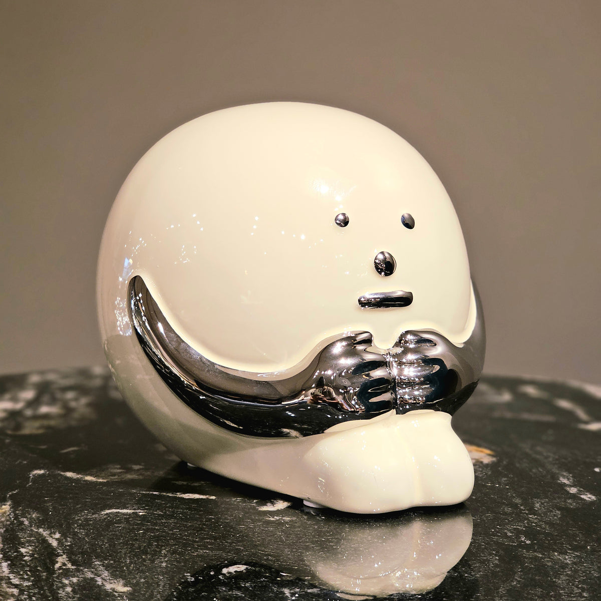 Contemporary resin figurine with polished chrome finish showcased as a modern artistic decor statement piece