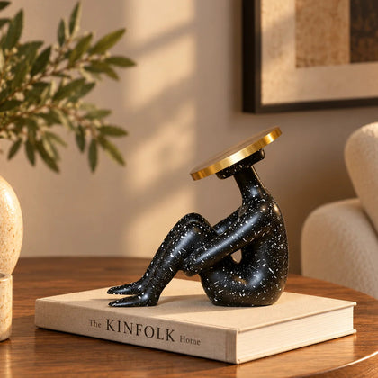 Luxury abstract seated human sculpture with black speckled finish and metallic circular head design for modern tabletop decor styling