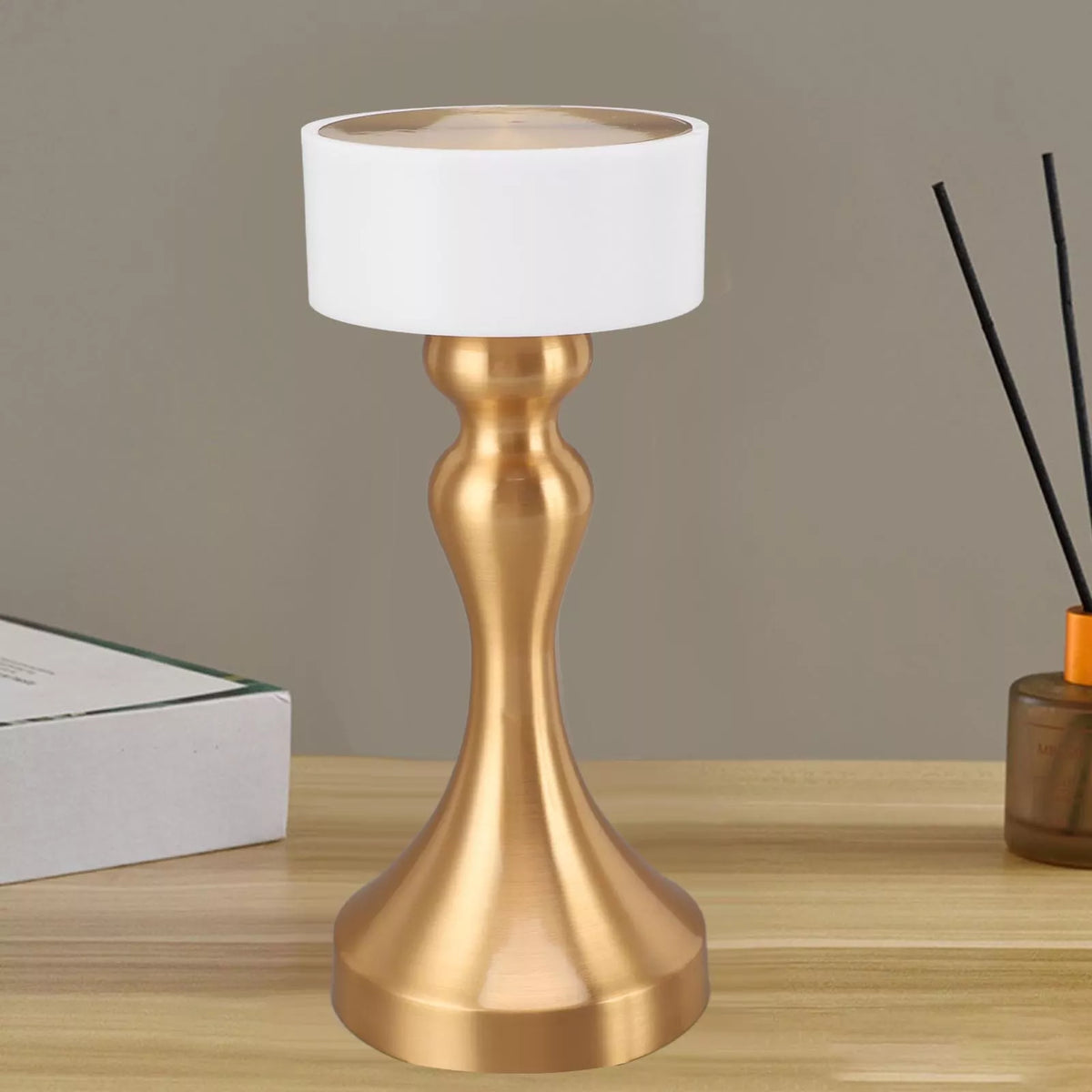 Luxury cordless LED table lamp featuring a brushed gold metal base with a minimalist white lampshade, ideal for bedside tables, restaurants, cafés, living rooms and modern designer interiors.