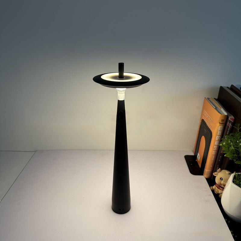 Modern cordless LED table lamp featuring a minimalist black conical base and floating circular shade, designed for ambient lighting in bedrooms, living rooms, offices, cafés and contemporary interiors.
