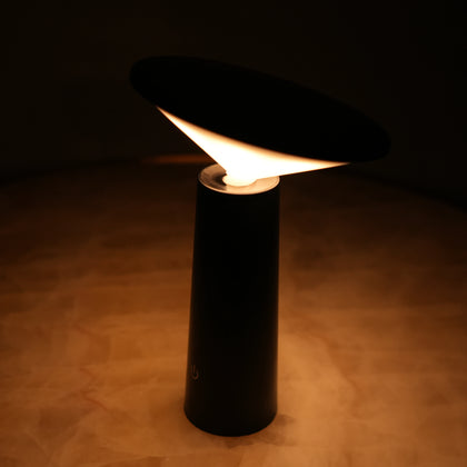 Modern black LED table lamp providing soft ambient illumination