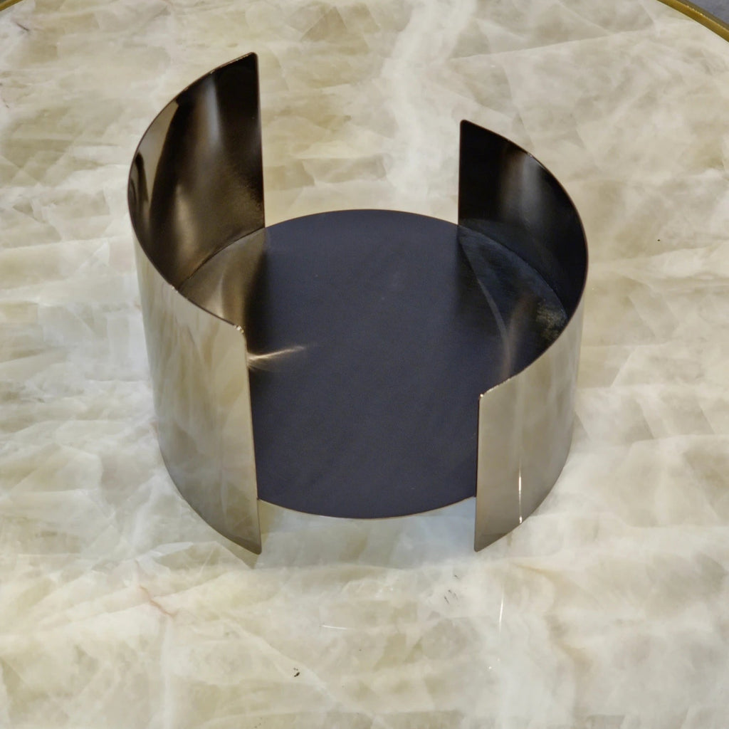 Contemporary curved metal stand for showcasing decorative objects.
