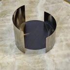Contemporary curved metal stand for showcasing decorative objects.