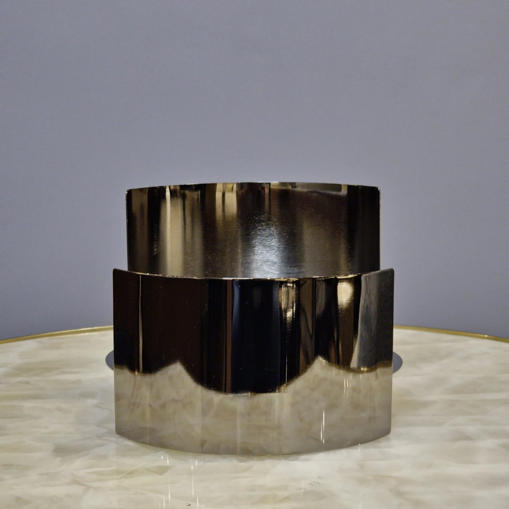 Contemporary curved metal stand for showcasing decorative objects.