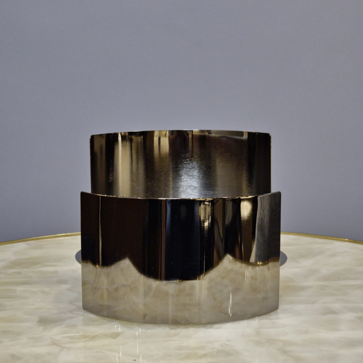 Contemporary curved metal stand for showcasing decorative objects.