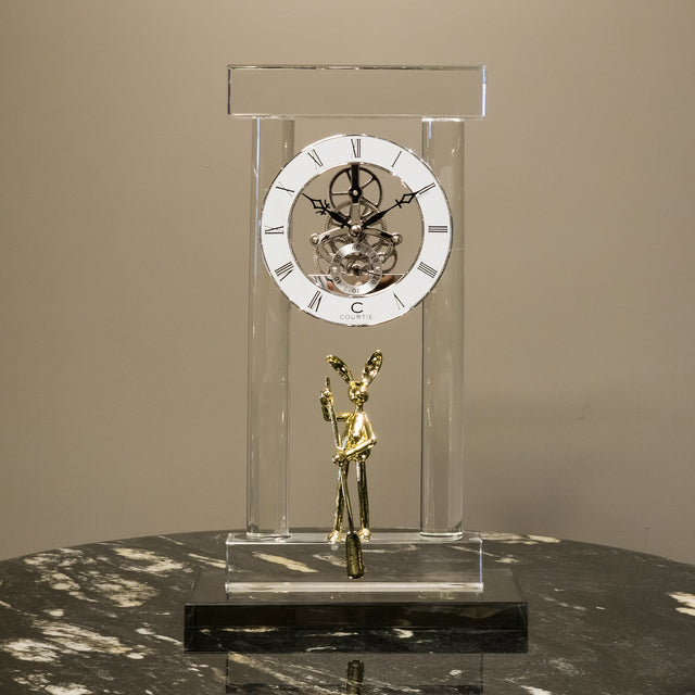 Abstract balancing sculpture with chrome spheres and a small gold figurine.