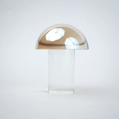 Mushroom-shaped lamp with gold top and clear base 