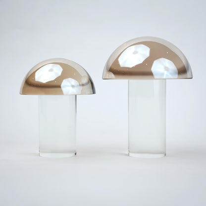 Mushroom-shaped lamp with gold top and clear base 