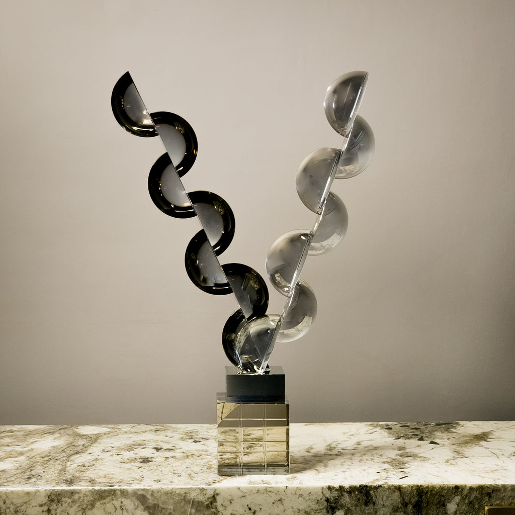 Designer geometric tabletop accent featuring transparent and smoked acrylic elements in a modern luxury interior