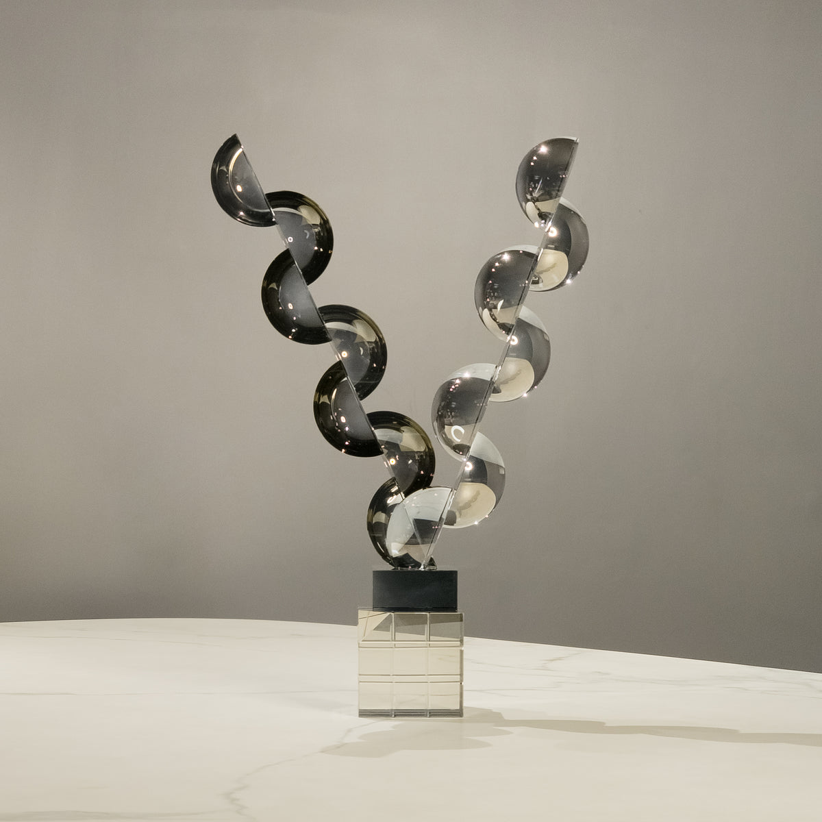 Artistic contemporary decor accent with balanced geometric acrylic forms showcased on a marble countertop setting