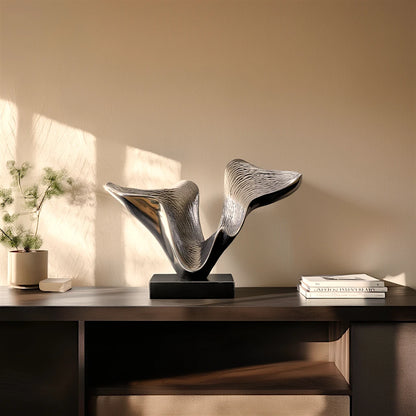 Abstract decor piece with fluid wave form, modern tabletop accent in silver finish on black base for luxury living room styling
