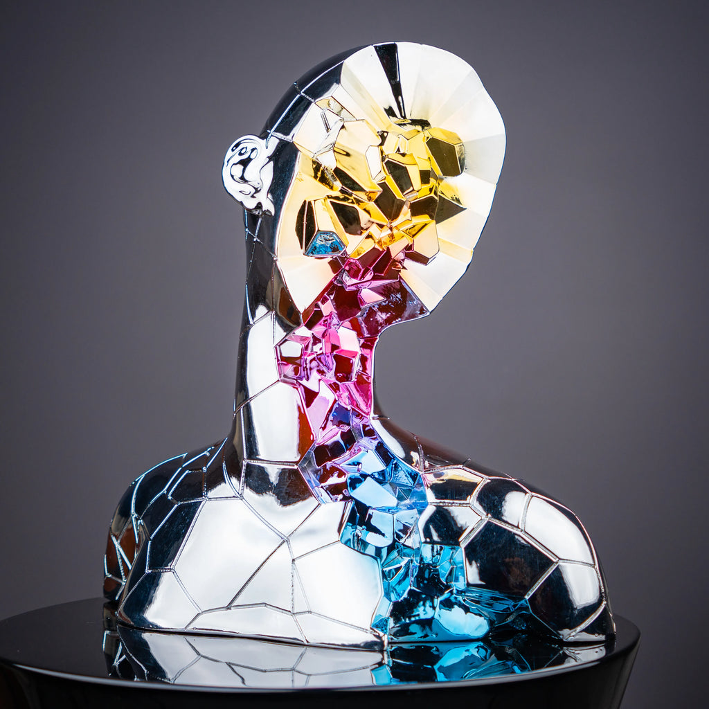 Modern prism face sculpture featuring chrome geometric detailing and vibrant artistic accents for elegant living room decor arrangements